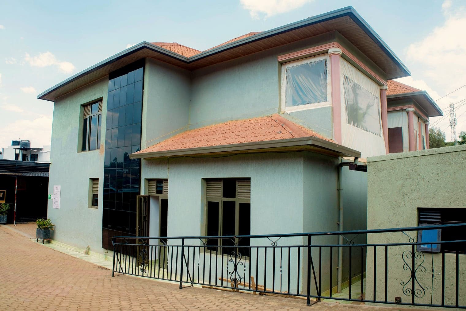 The guest house seen from the courtyard, with a tall glass stairwell and terracotta roof