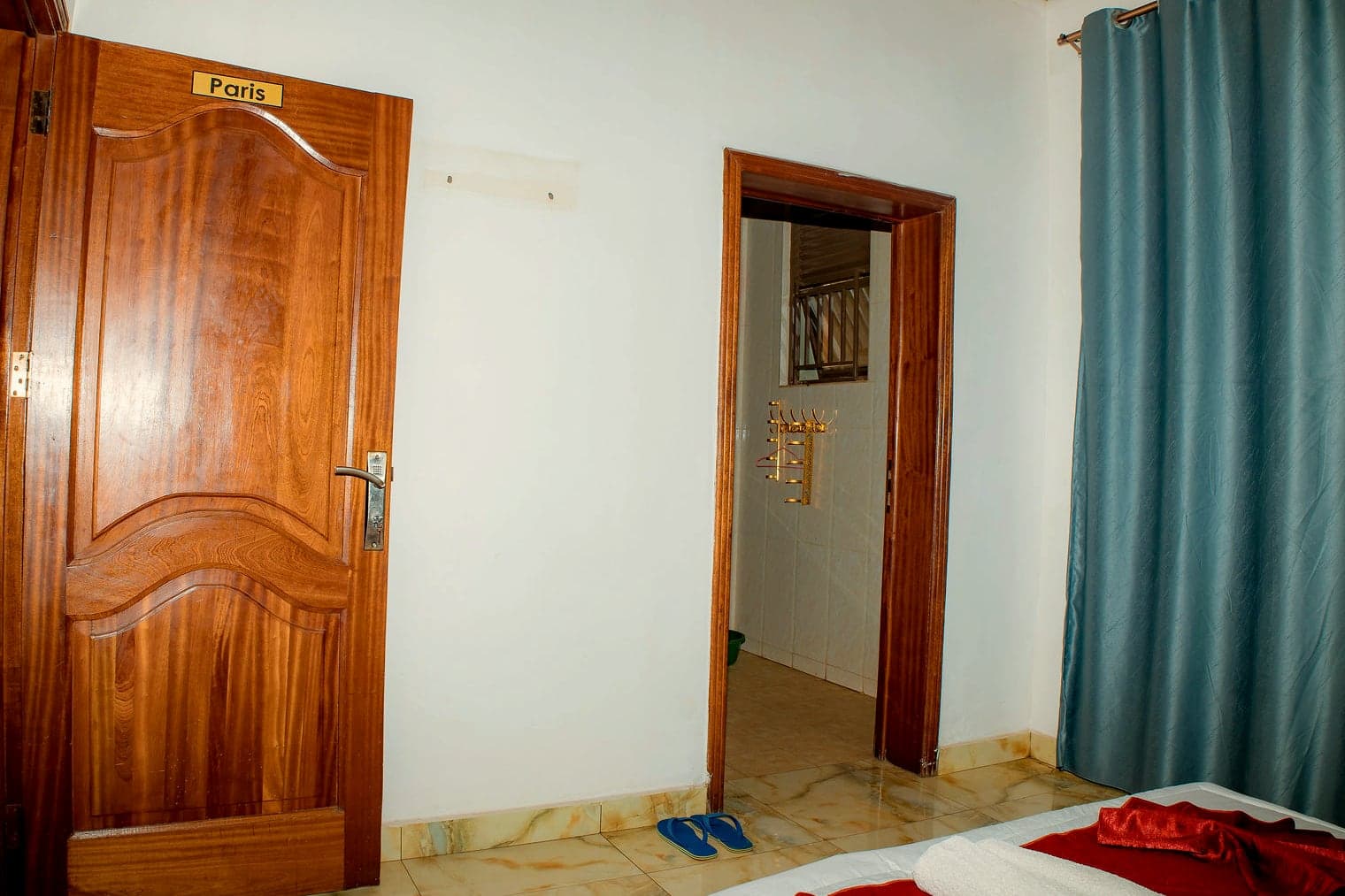The Paris room's wooden door with its name plate, and the bathroom doorway